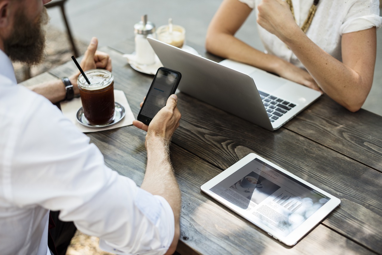 two person using gadgets on table